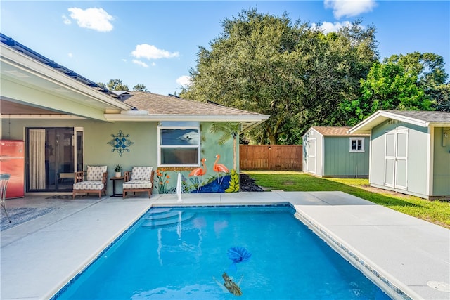 view of pool featuring a shed, a yard, and a patio area