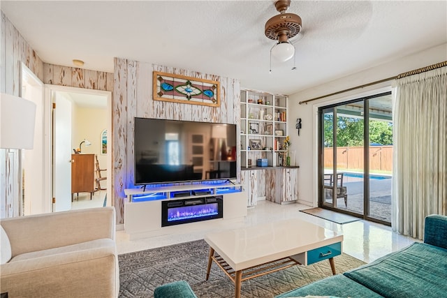 living room with ceiling fan and a textured ceiling