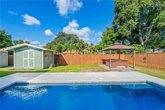 view of pool featuring a gazebo, a hot tub, a patio, a storage unit, and a lawn