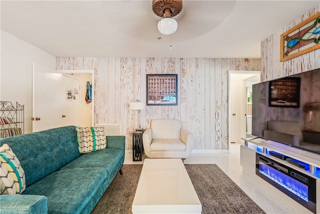 living room featuring a textured ceiling and ceiling fan