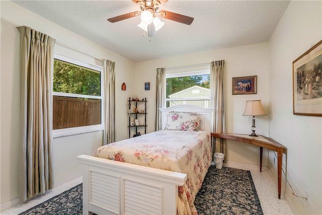 bedroom with a textured ceiling, multiple windows, and ceiling fan