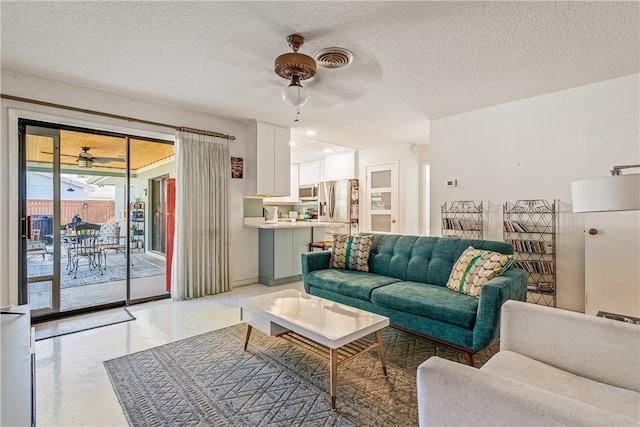 living room featuring a textured ceiling and ceiling fan