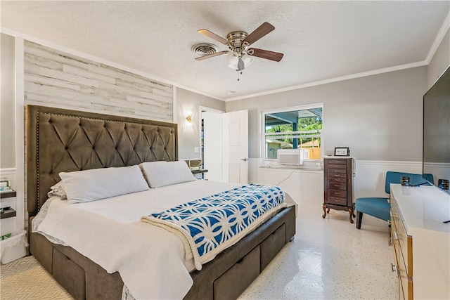 bedroom with ceiling fan, a textured ceiling, and crown molding