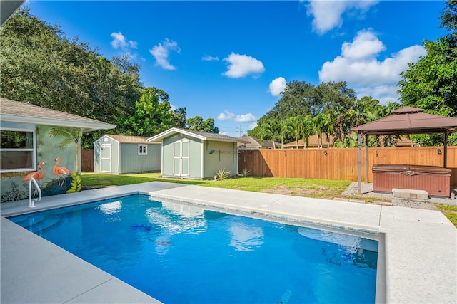 view of swimming pool with a hot tub, a gazebo, a lawn, and a shed