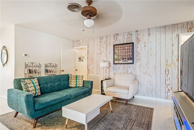 living room featuring a textured ceiling and ceiling fan