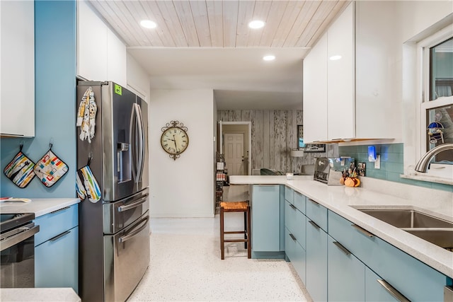 kitchen with decorative backsplash, white cabinetry, sink, and stainless steel appliances