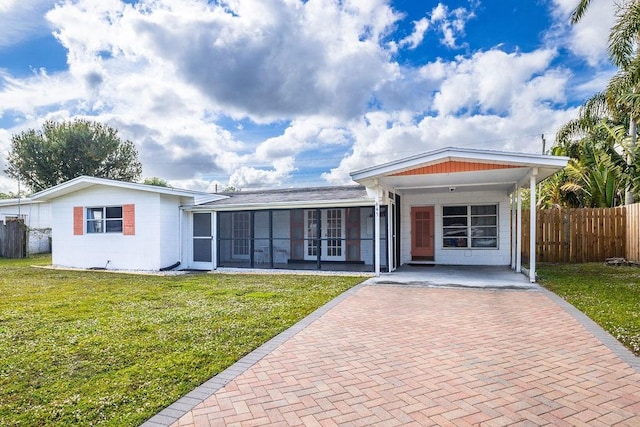 ranch-style house with a carport, a sunroom, and a front yard