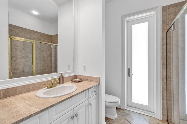 bathroom featuring tile patterned floors, vanity, an enclosed shower, and toilet