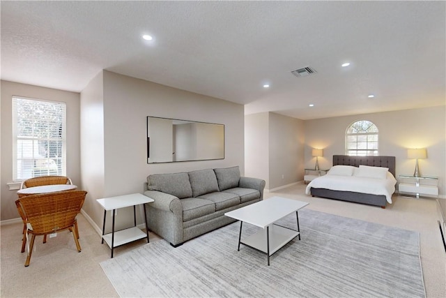 bedroom with light carpet and a textured ceiling