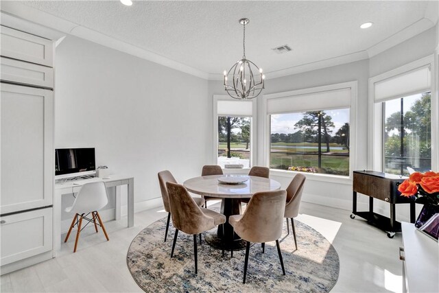 dining room featuring crown molding, a textured ceiling, and an inviting chandelier