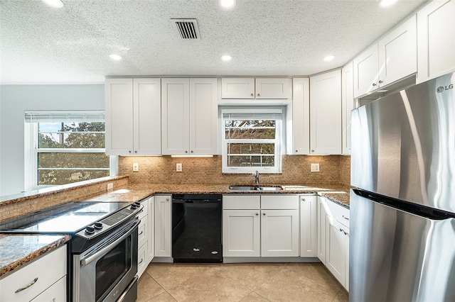 kitchen featuring a healthy amount of sunlight, appliances with stainless steel finishes, sink, and white cabinets