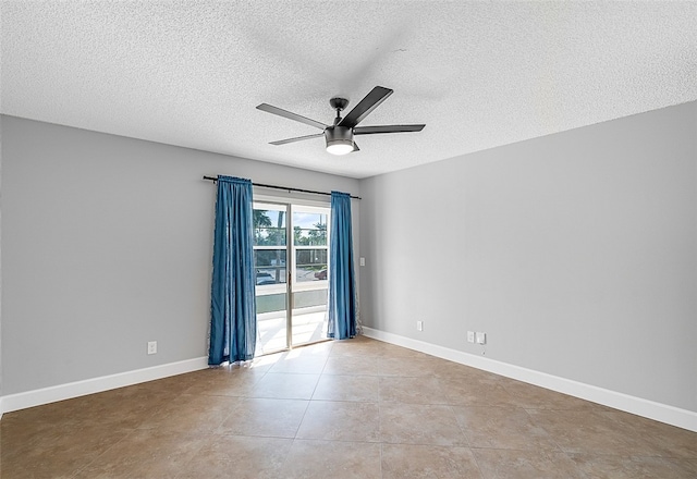 tiled empty room featuring ceiling fan and a textured ceiling