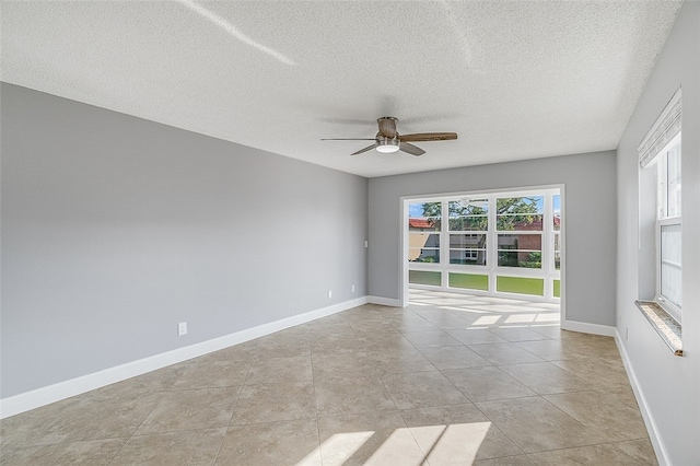 tiled empty room with a textured ceiling and ceiling fan