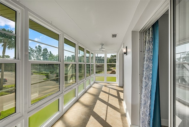 unfurnished sunroom with ceiling fan