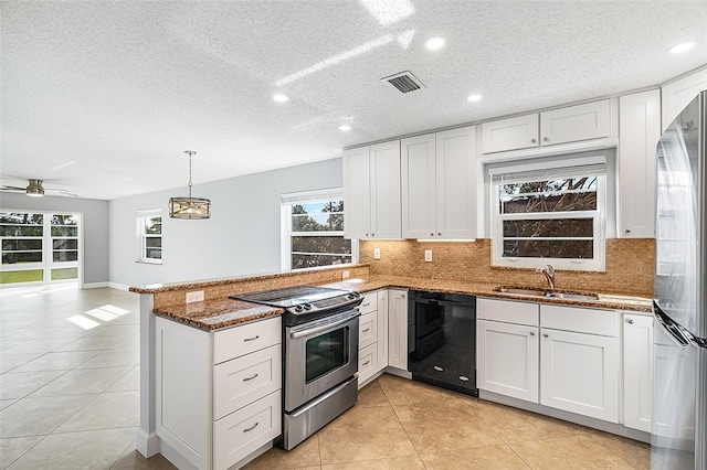 kitchen with stainless steel appliances, white cabinetry, sink, and dark stone counters