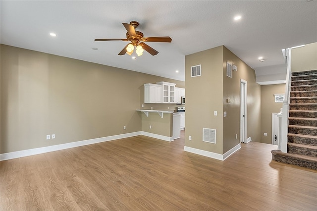 unfurnished living room with ceiling fan and light hardwood / wood-style floors