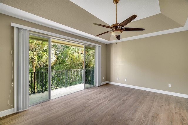 spare room featuring ceiling fan, light hardwood / wood-style floors, and a raised ceiling