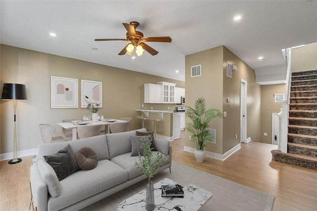 living room with ceiling fan and light hardwood / wood-style flooring