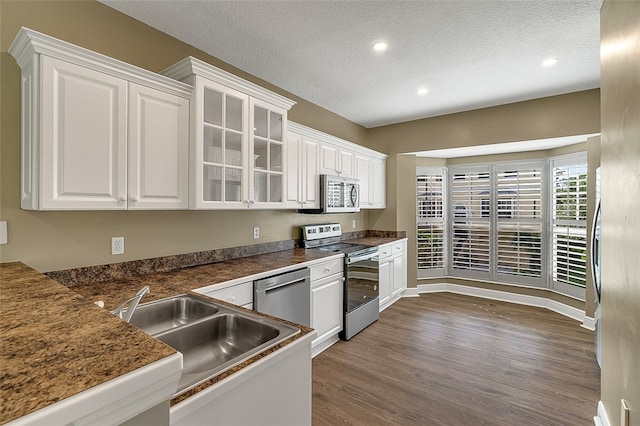 kitchen with white cabinetry, dark hardwood / wood-style flooring, a textured ceiling, and appliances with stainless steel finishes