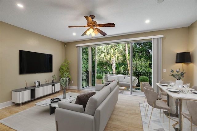 living room featuring light wood-type flooring and ceiling fan