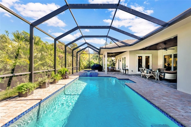 view of pool featuring french doors, a patio area, glass enclosure, an in ground hot tub, and ceiling fan