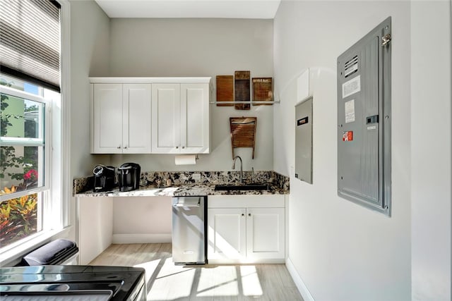 kitchen featuring white cabinetry, sink, light hardwood / wood-style floors, and dark stone counters