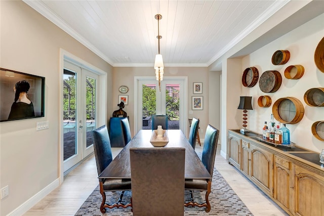 dining space featuring ornamental molding, a healthy amount of sunlight, light hardwood / wood-style floors, and french doors