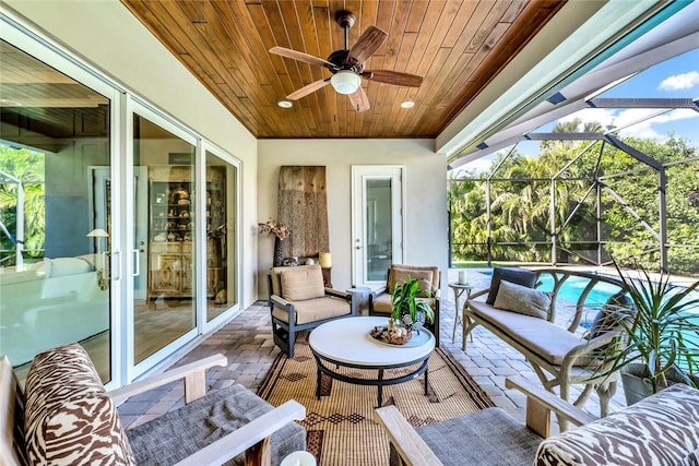 view of patio with a lanai, an outdoor hangout area, and ceiling fan