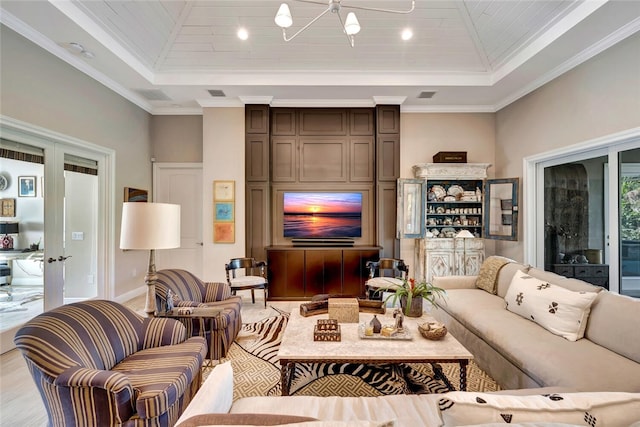 living room with a towering ceiling, ornamental molding, and a tray ceiling