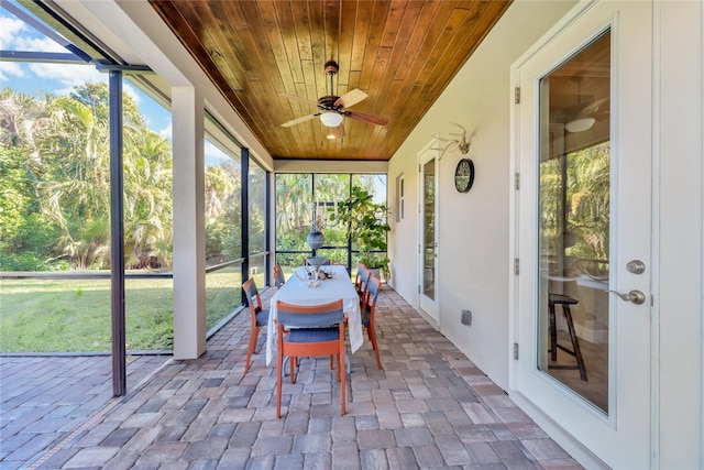 unfurnished sunroom featuring wood ceiling and ceiling fan