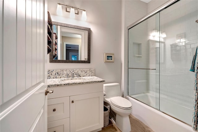 full bathroom featuring enclosed tub / shower combo, vanity, toilet, and tile patterned flooring