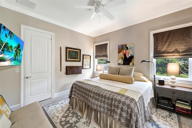 bedroom with ceiling fan, ornamental molding, and wood-type flooring