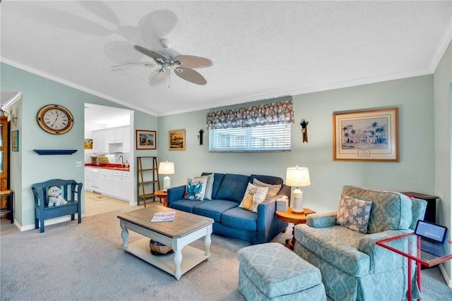 living room featuring light carpet, ornamental molding, a textured ceiling, baseboards, and ceiling fan