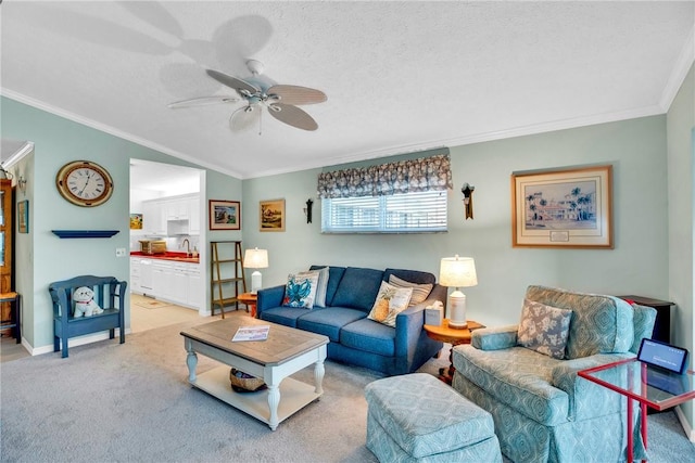 living room with ceiling fan, light colored carpet, a textured ceiling, and crown molding