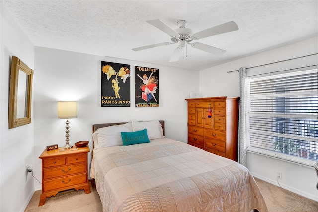 bedroom with ceiling fan, a textured ceiling, baseboards, and carpet floors