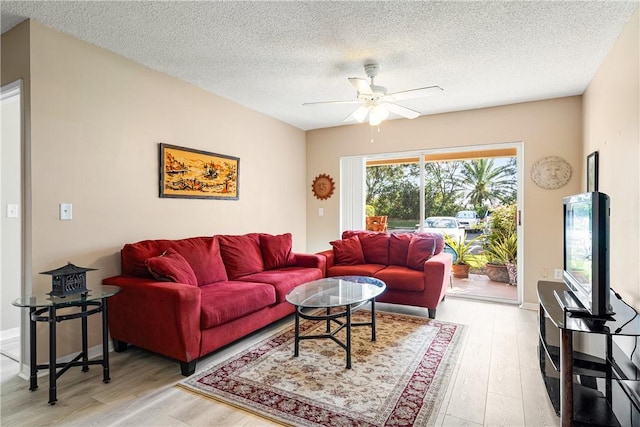 living room with a textured ceiling, light hardwood / wood-style floors, and ceiling fan