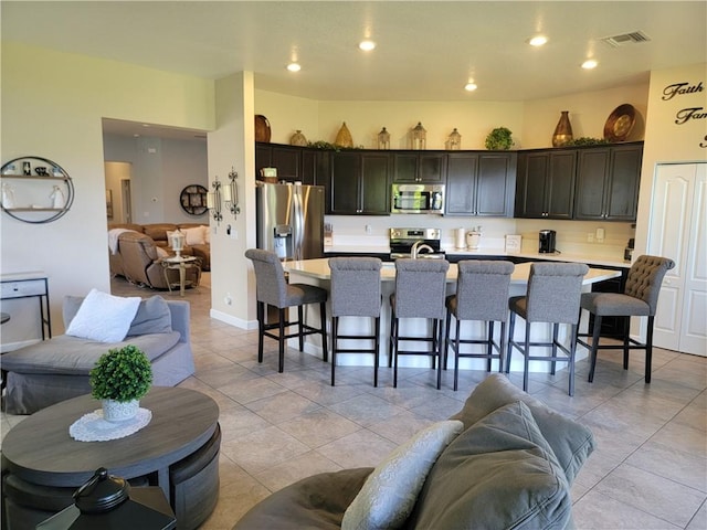 1808 Berkshire Cir SW, Vero Beach, FL 32968 - kitchen with stainless steel appliances, open floor plan, light countertops, a kitchen bar, and recessed lighting