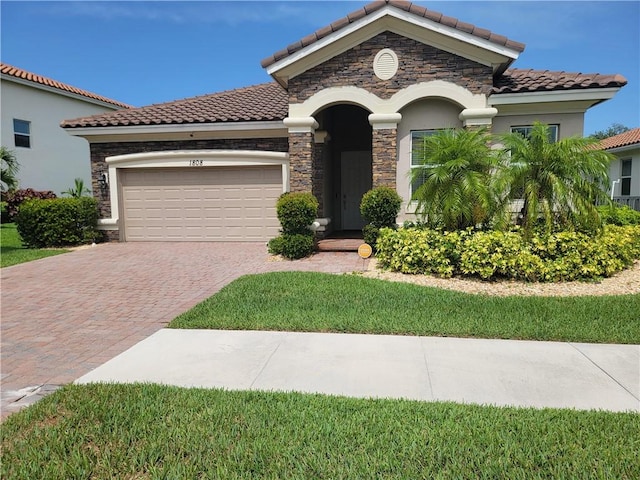 1808 Berkshire Cir SW, Vero Beach, FL 32968 - mediterranean / spanish-style house with stone siding, a tile roof, decorative driveway, and stucco siding