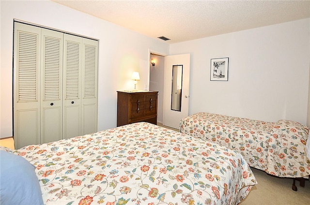 carpeted bedroom featuring a textured ceiling and a closet