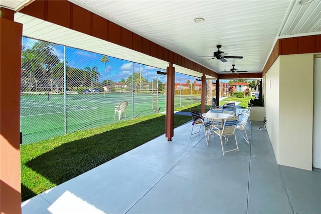 view of patio featuring ceiling fan and tennis court