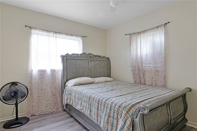 bedroom featuring light hardwood / wood-style flooring, multiple windows, and ceiling fan