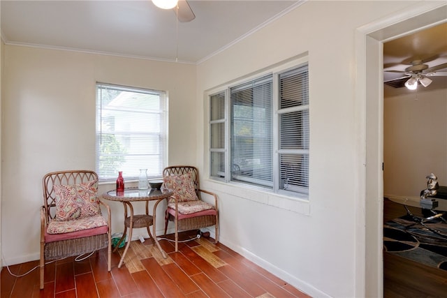 living area with ceiling fan, wood-type flooring, and crown molding