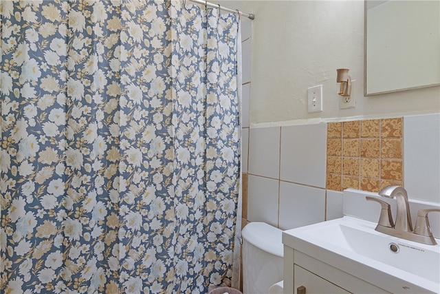 bathroom featuring tile walls, walk in shower, vanity, and toilet