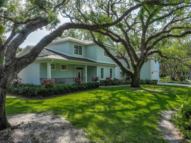 7330 36th Ct, Vero Beach, FL 32967 - view of front of home featuring covered porch, a front yard, and stucco siding