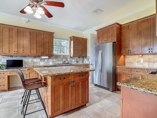 7330 36th Ct, Vero Beach, FL 32967 - kitchen with ceiling fan, freestanding refrigerator, backsplash, visible vents, and a kitchen island