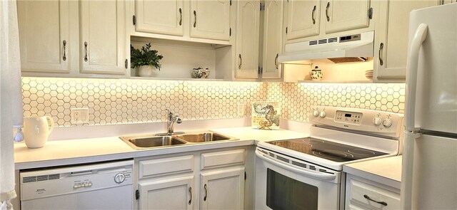 kitchen with decorative backsplash, white cabinetry, white appliances, and sink