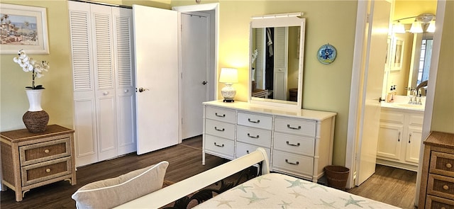 bedroom with a closet, ensuite bathroom, dark hardwood / wood-style flooring, and sink