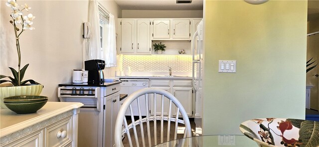 kitchen featuring white cabinets, tasteful backsplash, and sink