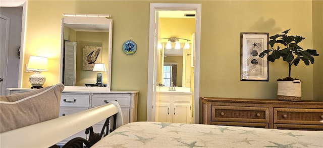 bedroom featuring ensuite bath and sink