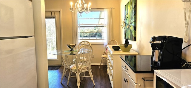 dining room featuring a wealth of natural light, dark hardwood / wood-style flooring, and an inviting chandelier